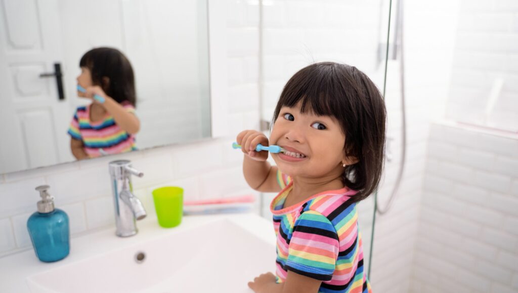 bambina che si spazzola i denti
