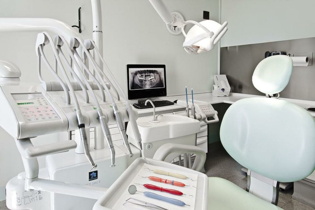 Interno di uno studio dentistico moderno e accogliente con attrezzature digitali.